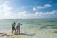 A guide points out a fish to an angler in the Bahamas.